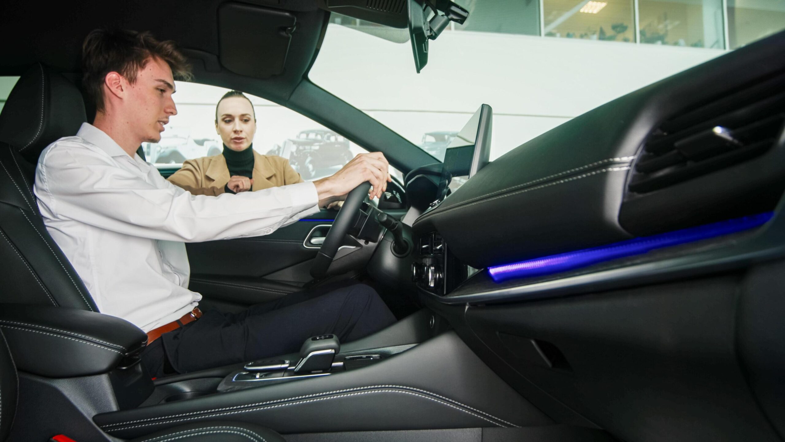 car-dealer-showing-a-car-to-a-customer-in-a-showroom-concept-of-purchase-and-assistance-free-photo